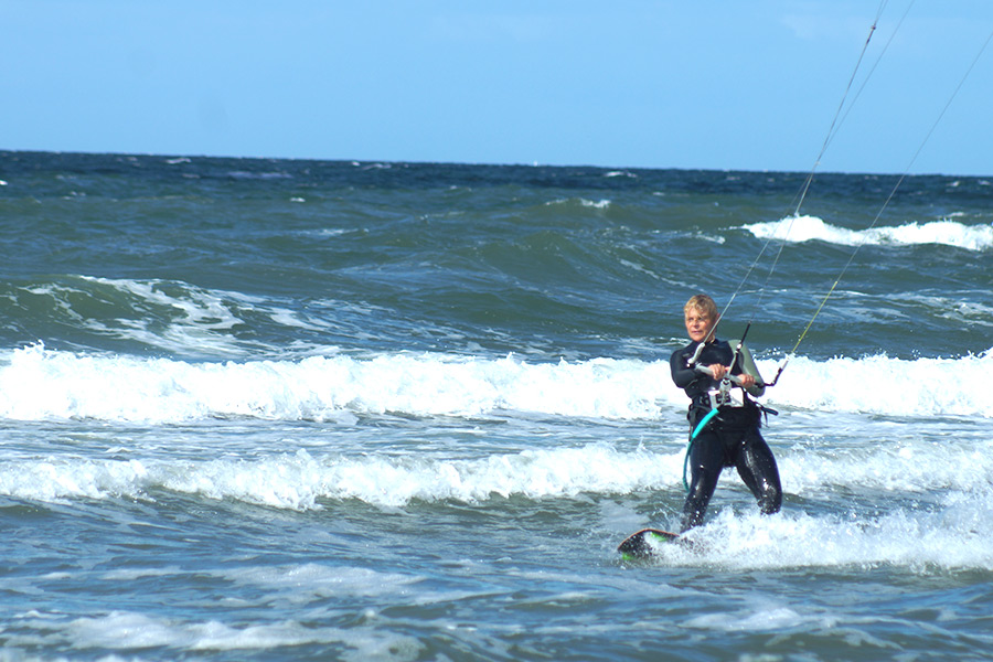 Anfänger übt Kitesurfen mit Lehrer im Wasser am Salzhaff